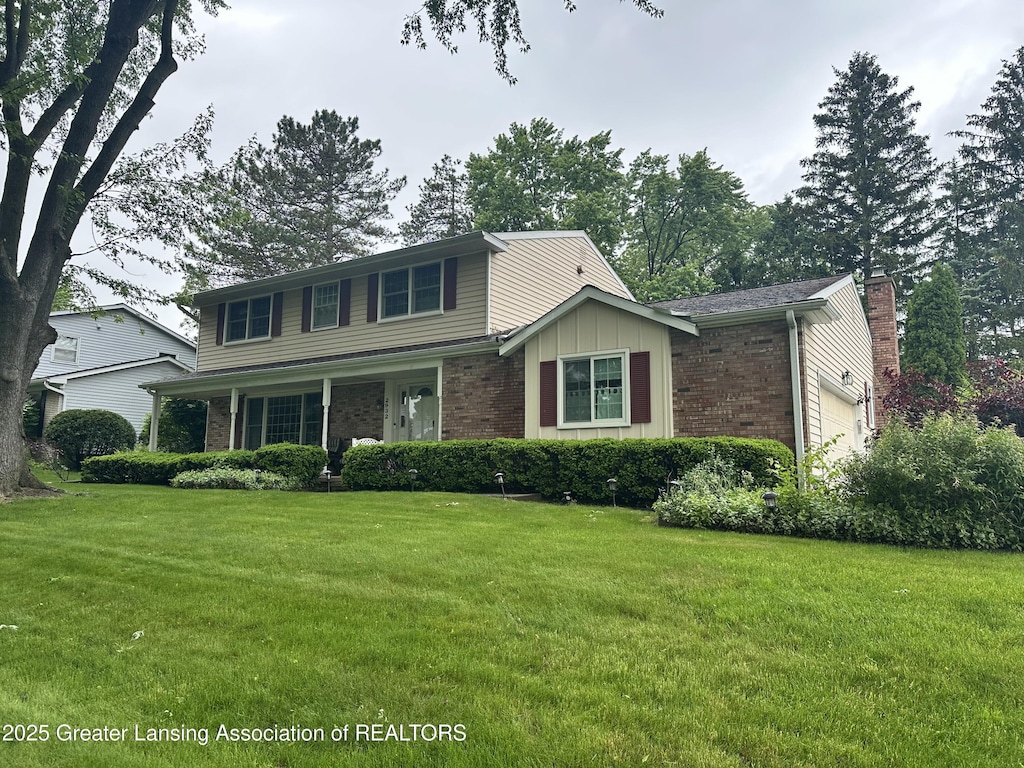 2932 Crestwood Dr, East Lansing, MI 48823 - traditional-style home with brick siding, a front lawn, and a chimney