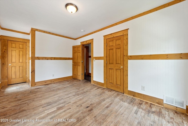 402 W Cesar E Chavez Ave, Lansing, MI 48906 - spare room featuring hardwood / wood-style floors, baseboards, and wood walls