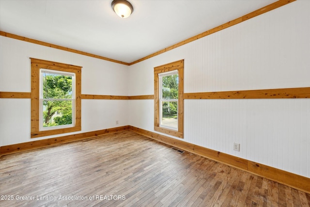 402 W Cesar E Chavez Ave, Lansing, MI 48906 - unfurnished room with healthy amount of natural light, hardwood / wood-style flooring, and baseboards