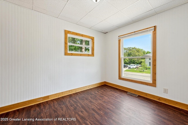 402 W Cesar E Chavez Ave, Lansing, MI 48906 - empty room with dark wood finished floors, baseboards, and wood walls