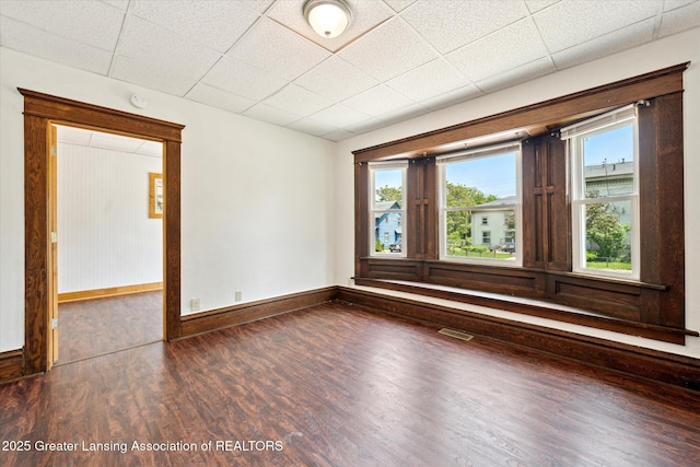 402 W Cesar E Chavez Ave, Lansing, MI 48906 - empty room featuring wood finished floors, plenty of natural light, baseboards, and a drop ceiling