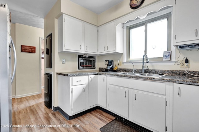 7713 Jon Scott Dr, Grand Ledge, MI 48837 - kitchen with a sink, light wood-type flooring, freestanding refrigerator, and white cabinets