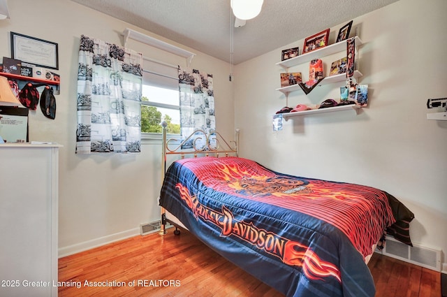 7713 Jon Scott Dr, Grand Ledge, MI 48837 - bedroom featuring wood finished floors, baseboards, and a textured ceiling