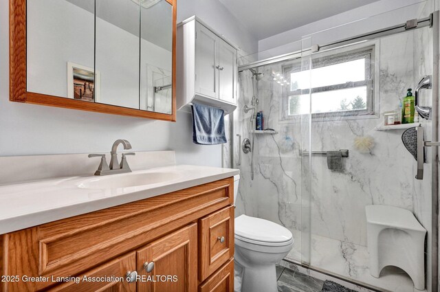 7713 Jon Scott Dr, Grand Ledge, MI 48837 - bathroom featuring marble finish floors, toilet, vanity, and a marble finish shower