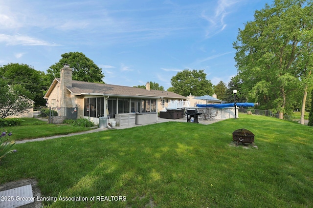 7713 Jon Scott Dr, Grand Ledge, MI 48837 - back of house with a hot tub, a fire pit, a chimney, and a sunroom