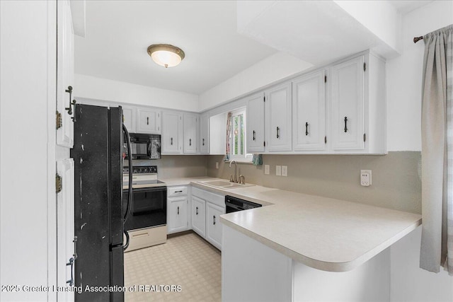 1941 S Royston Rd, Eaton Rapids, MI 48827 - kitchen featuring black appliances, a sink, a peninsula, light countertops, and white cabinets