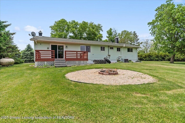 1941 S Royston Rd, Eaton Rapids, MI 48827 - rear view of property with a wooden deck, a chimney, an outdoor fire pit, and a yard