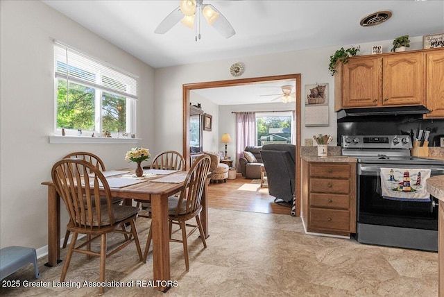 1727 Springfield Ln, Lansing, MI 48912 - kitchen with stainless steel electric range oven, ceiling fan, under cabinet range hood, light countertops, and light floors