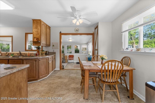 1727 Springfield Ln, Lansing, MI 48912 - dining space featuring healthy amount of natural light, a ceiling fan, light flooring, and baseboards