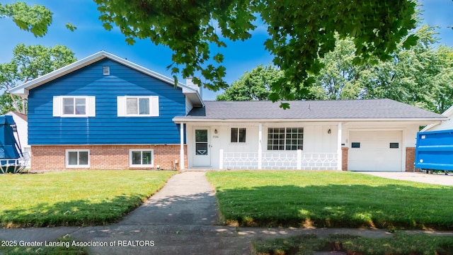 3326 W Willow St, Lansing, MI 48917 - tri-level home featuring an attached garage, a front lawn, concrete driveway, brick siding, and a chimney