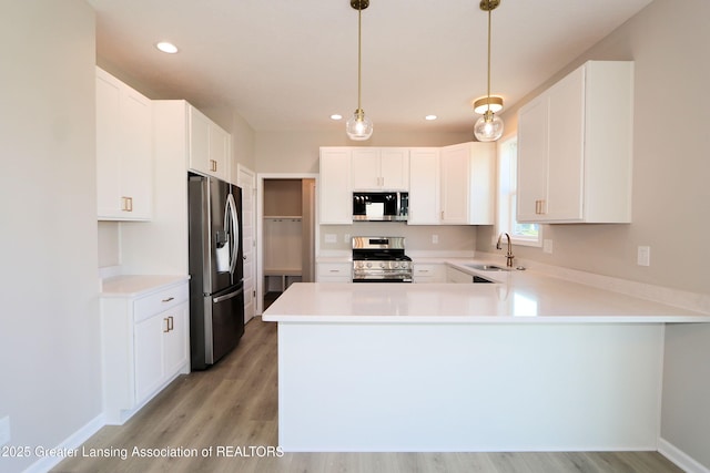 605 Landbridge, Perry, MI 48872 - kitchen with appliances with stainless steel finishes, a peninsula, light wood-style floors, light countertops, and recessed lighting