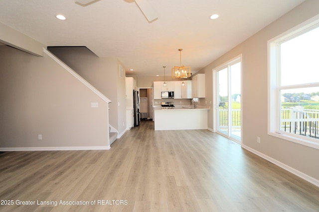 605 Landbridge, Perry, MI 48872 - unfurnished living room featuring stairway, light wood-type flooring, recessed lighting, and a chandelier