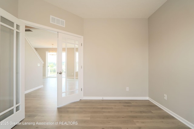 605 Landbridge, Perry, MI 48872 - unfurnished room with wood finished floors, a chandelier, and french doors