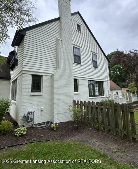 1141 N Genesee Dr, Lansing, MI 48915 - back of house featuring a chimney and brick siding