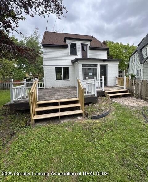 1141 N Genesee Dr, Lansing, MI 48915 - rear view of house featuring brick siding, a wooden deck, and a shingled roof
