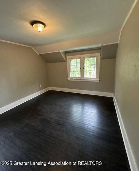 1141 N Genesee Dr, Lansing, MI 48915 - additional living space featuring baseboards, lofted ceiling, and dark wood-style flooring