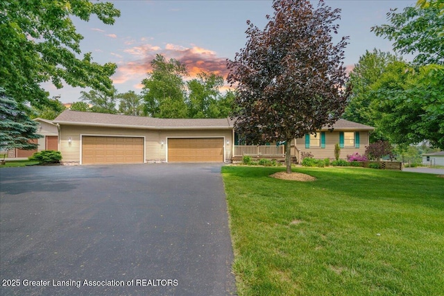 1055 Hull Rd, Mason, MI 48854 - view of front facade featuring driveway, a front lawn, and a garage