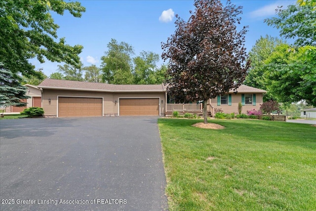 1055 Hull Rd, Mason, MI 48854 - view of front of house featuring asphalt driveway, a front lawn, and an attached garage
