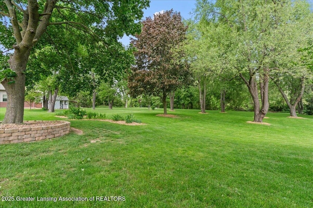 1055 Hull Rd, Mason, MI 48854 - view of green lawn featuring view of wooded area