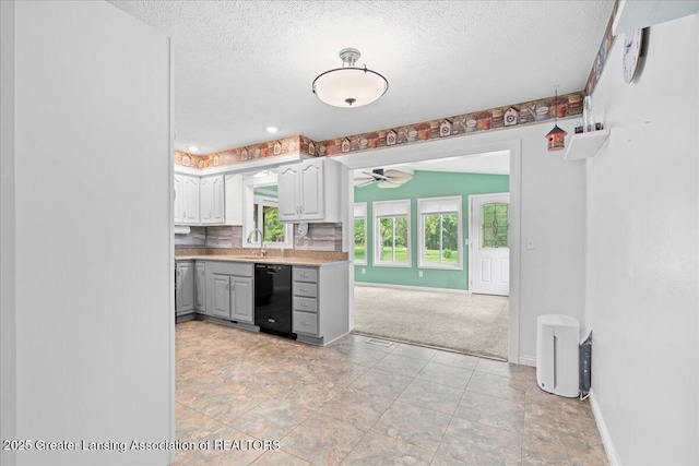 1055 Hull Rd, Mason, MI 48854 - kitchen with black dishwasher, a textured ceiling, gray cabinets, light countertops, and baseboards
