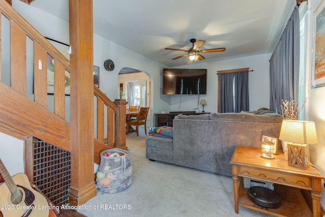 826 Clyde St, Lansing, MI 48915 - living room featuring carpet flooring, arched walkways, stairs, and ceiling fan