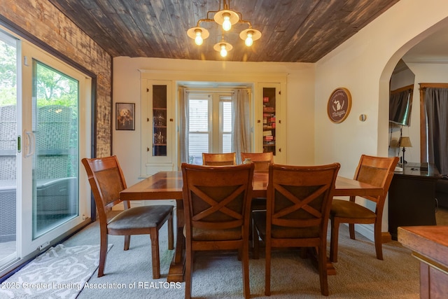 826 Clyde St, Lansing, MI 48915 - dining room featuring arched walkways, wooden ceiling, a chandelier, and carpet