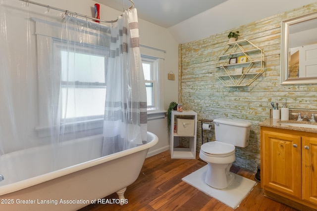 826 Clyde St, Lansing, MI 48915 - full bath featuring vaulted ceiling, toilet, vanity, wood finished floors, and wallpapered walls