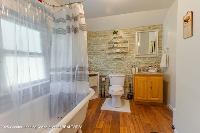 826 Clyde St, Lansing, MI 48915 - full bathroom with wood finished floors, toilet, vanity, shower / tub combo, and baseboards