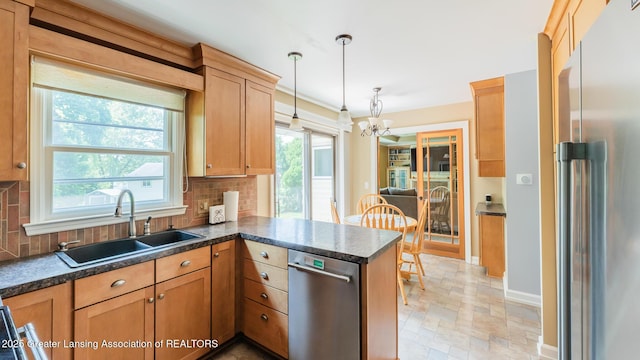 120 Chanticleer Trl, Lansing, MI 48917 - kitchen with stainless steel appliances, a chandelier, a sink, and backsplash