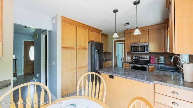 120 Chanticleer Trl, Lansing, MI 48917 - kitchen featuring appliances with stainless steel finishes, a sink, backsplash, dark countertops, and a peninsula