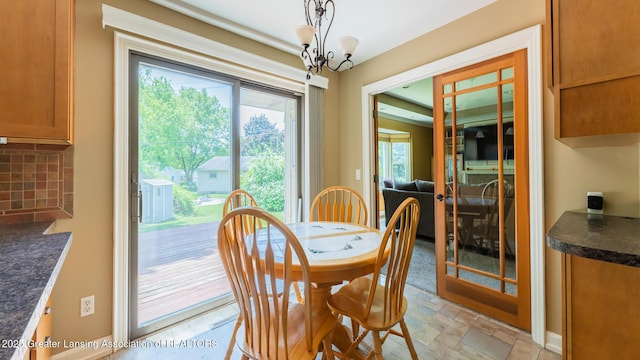 120 Chanticleer Trl, Lansing, MI 48917 - dining area with plenty of natural light, a chandelier, stone finish floors, and french doors