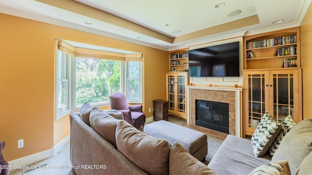 120 Chanticleer Trl, Lansing, MI 48917 - living room featuring baseboards, a tiled fireplace, ornamental molding, a raised ceiling, and recessed lighting