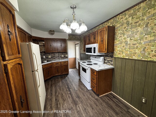 1143 Lathrop St, Lansing, MI 48912 - kitchen with white appliances, dark wood-type flooring, a chandelier, light countertops, and a sink