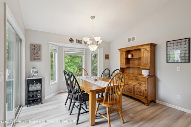 11782 Sara Ann Dr, Dewitt, MI 48820 - dining area with a chandelier, vaulted ceiling, light wood-style floors, and baseboards
