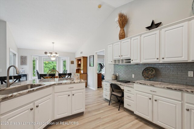 11782 Sara Ann Dr, Dewitt, MI 48820 - kitchen with a sink, backsplash, a chandelier, light wood-style flooring, and light stone countertops