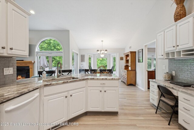 11782 Sara Ann Dr, Dewitt, MI 48820 - kitchen featuring dishwasher, a sink, lofted ceiling, tasteful backsplash, and light wood finished floors