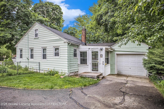 4434 Holt Rd, Holt, MI 48842 - single story home featuring a garage, a chimney, asphalt driveway, and roof with shingles
