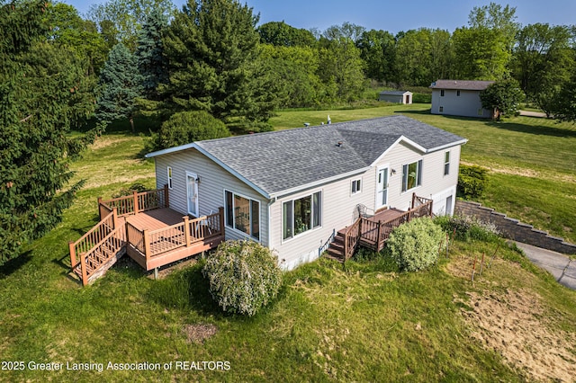1200 S Michigan Rd, Eaton Rapids, MI 48827 - rear view of property with a shingled roof, a lawn, a wooden deck, and an attached garage