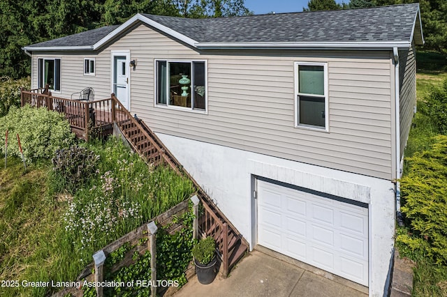 1200 S Michigan Rd, Eaton Rapids, MI 48827 - single story home with an attached garage, a shingled roof, driveway, and a wooden deck