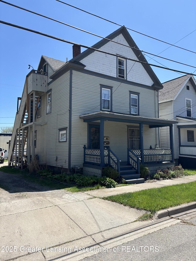 1417 Reo Ave, Lansing, MI 48910 - view of front of home with a chimney, stairs, and a porch
