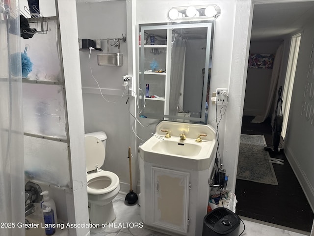 1417 Reo Ave, Lansing, MI 48910 - bathroom featuring vanity, toilet, and baseboards