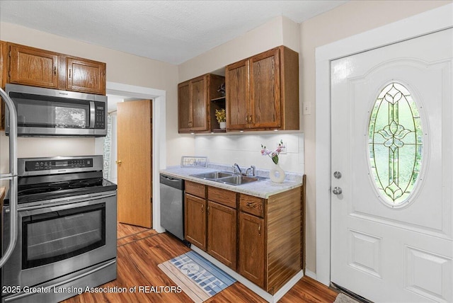 1128 Hickory St, Lansing, MI 48912 - kitchen with stainless steel appliances, a sink, light countertops, and wood finished floors