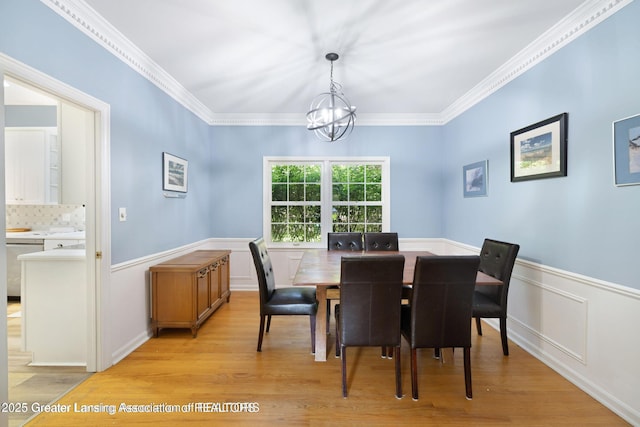 2038 Woodfield Rd, Okemos, MI 48864 - dining space with a chandelier, light wood-type flooring, wainscoting, and crown molding