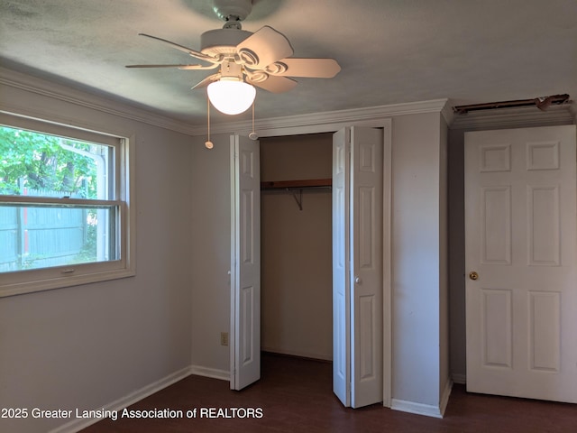 15632 Park Lake Rd, East Lansing, MI 48823 - unfurnished bedroom featuring baseboards, a closet, crown molding, a ceiling fan, and dark wood-style floors