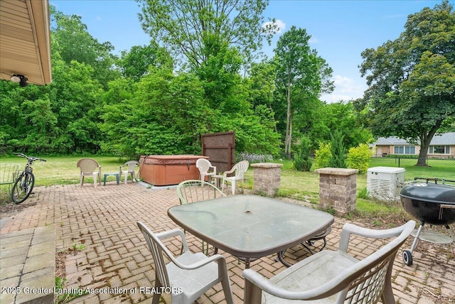 5195 E Brookfield Dr, East Lansing, MI 48823 - view of patio / terrace featuring a hot tub, outdoor dining area, and view of scattered trees