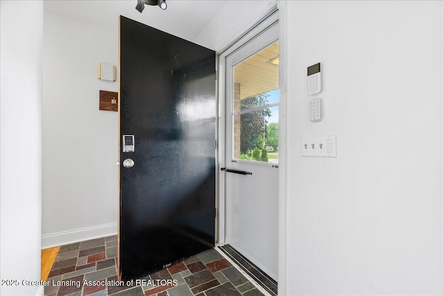 5195 E Brookfield Dr, East Lansing, MI 48823 - doorway featuring stone finish flooring and baseboards