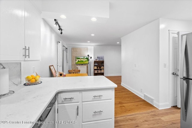 5195 E Brookfield Dr, East Lansing, MI 48823 - kitchen with a peninsula, appliances with stainless steel finishes, white cabinets, recessed lighting, and light wood-style floors