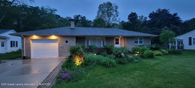 5195 E Brookfield Dr, East Lansing, MI 48823 - single story home with an attached garage, a chimney, driveway, a front lawn, and brick siding