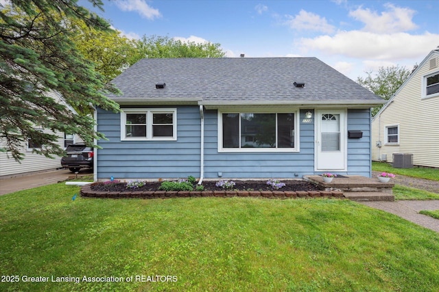 1718 Victor Ave, Lansing, MI 48910 - view of front of home with central air condition unit, roof with shingles, and a front lawn
