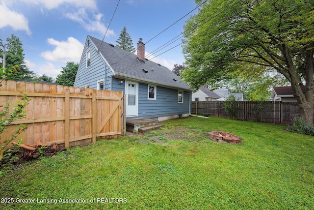 1718 Victor Ave, Lansing, MI 48910 - rear view of house with a chimney, roof with shingles, and a fire pit